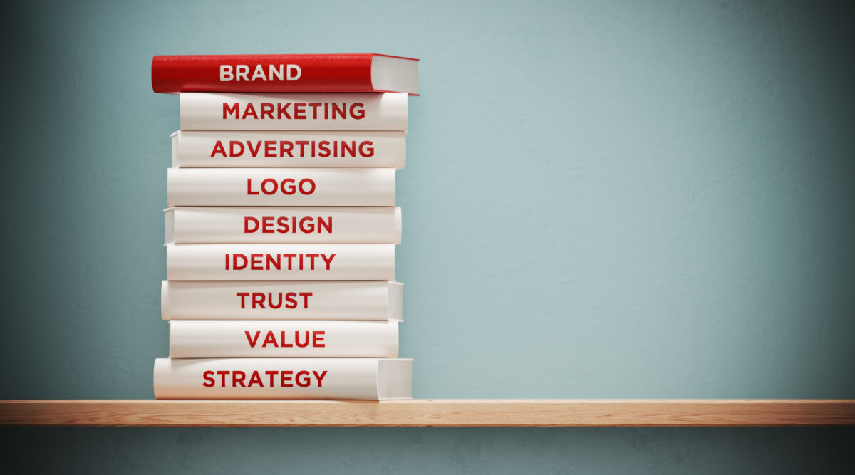 A stack of books titles with different aspects of your brand like your logo, marketing, advertising, value, and identity.