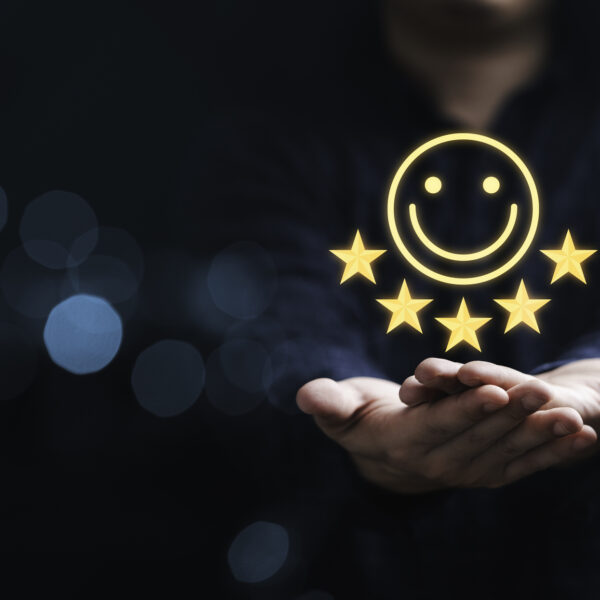 A pair of hands shown with a superimposed smiling face and five stars above it, indicating a positive brand perception.